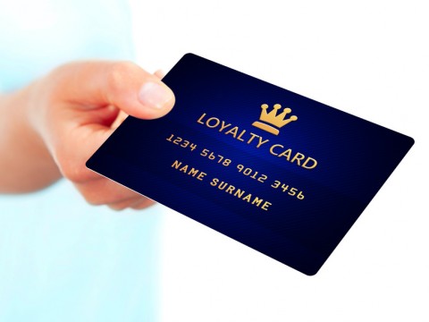 hand holding loyalty card isolated over white